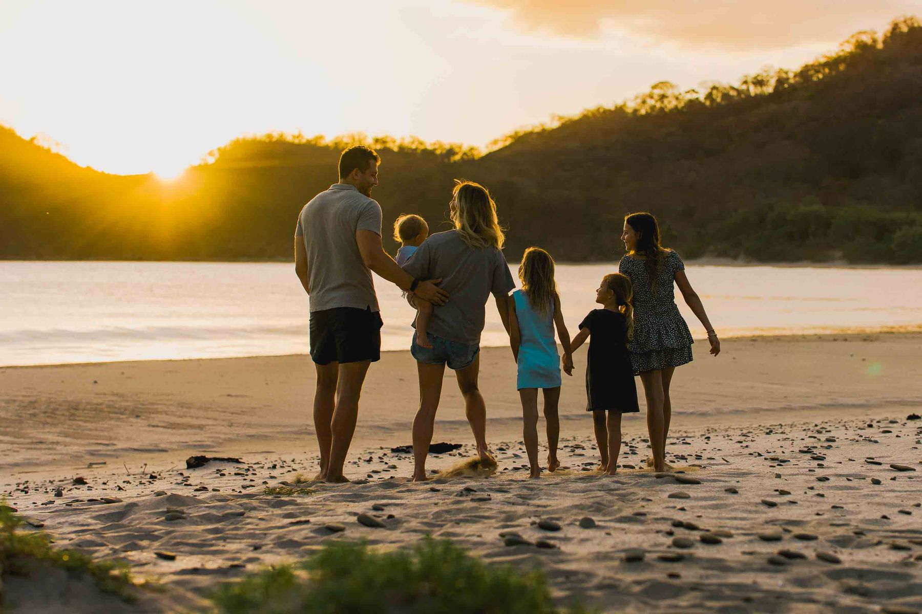 A family of five walks along the beach at sunset in San Juan del Sur