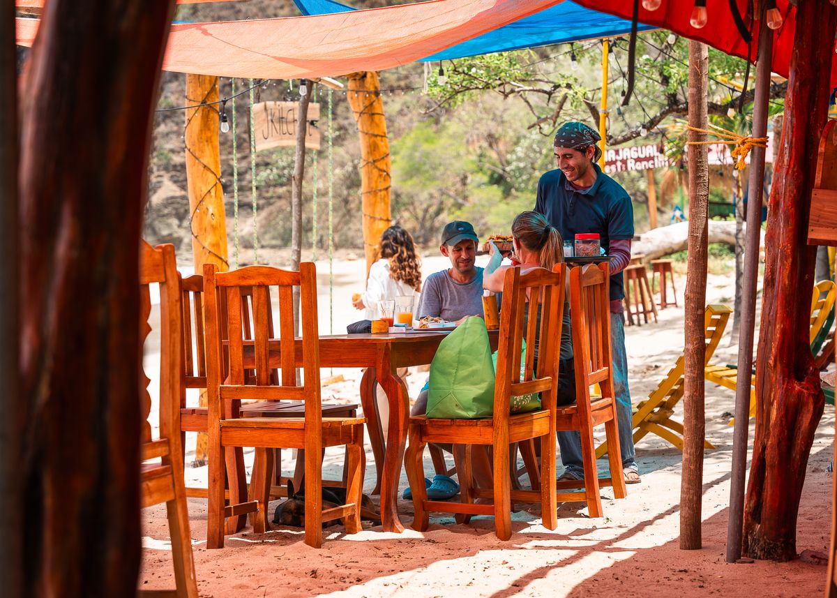 A family is served lunch at a beachside restaurant